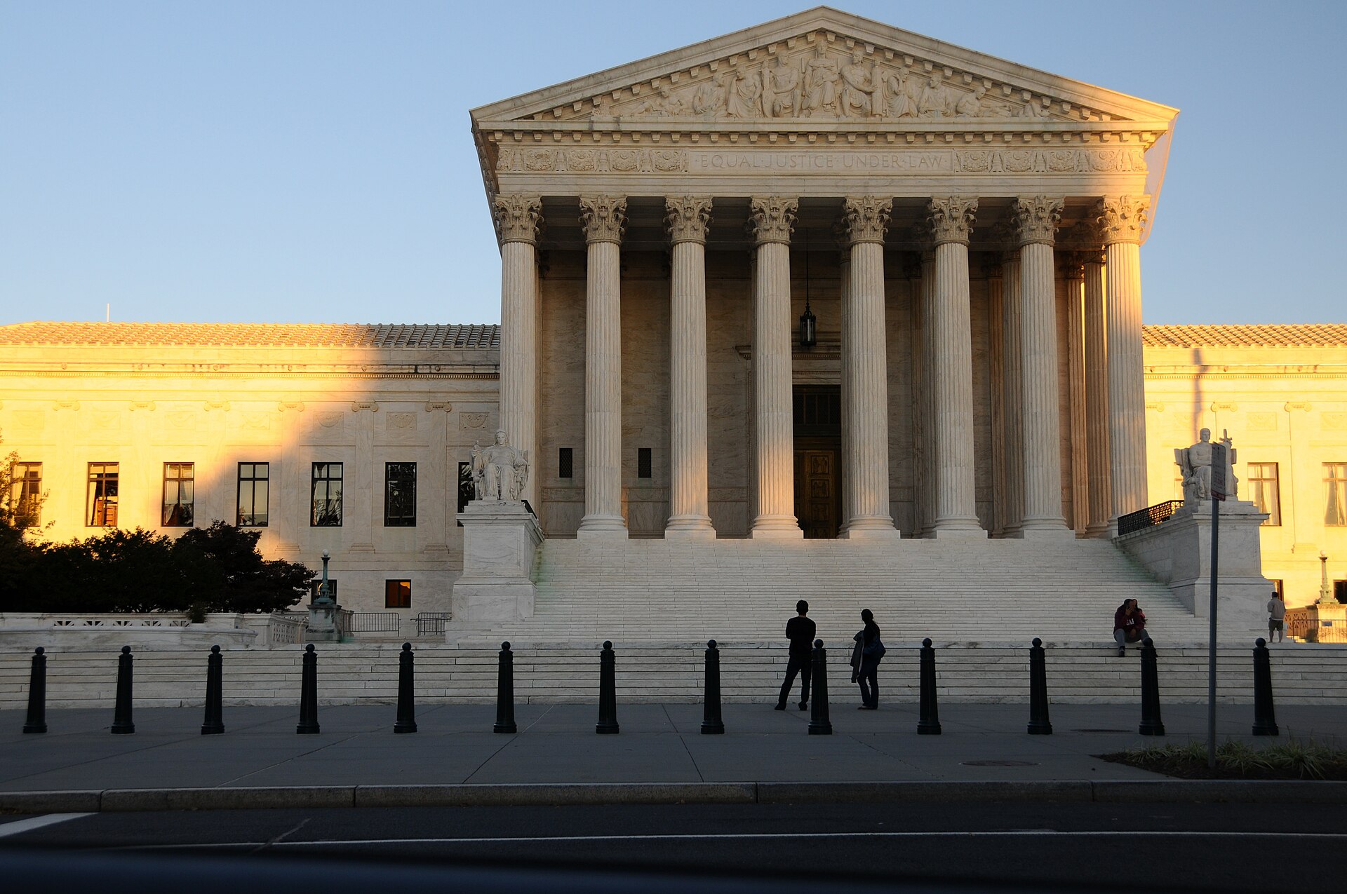 Warm evening light falls on the columns of the Supreme Court above visitors on its steps.